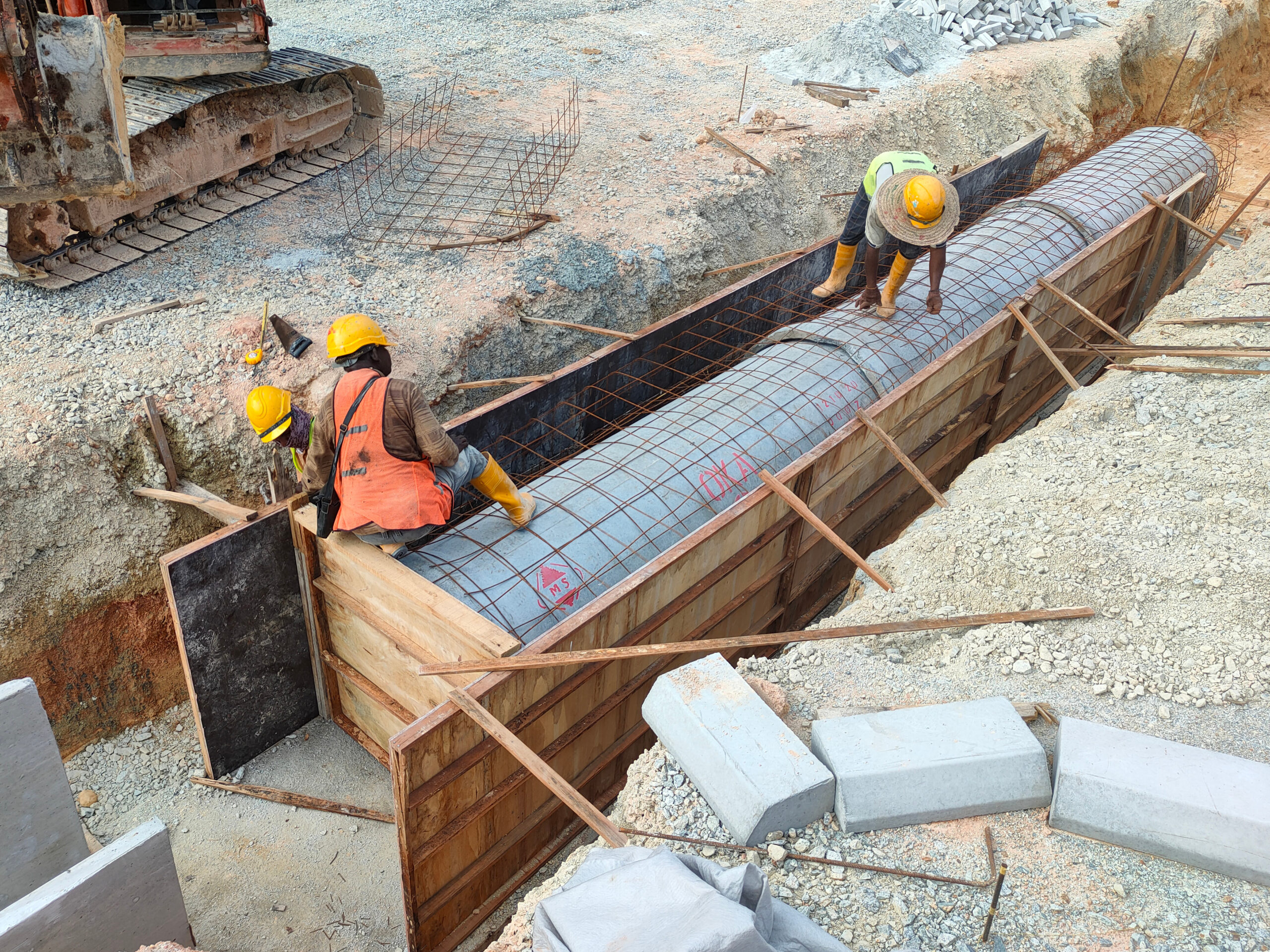 Workers constructing underground drain at the construction site. It is used to channel stormwater to prevent flash floods.